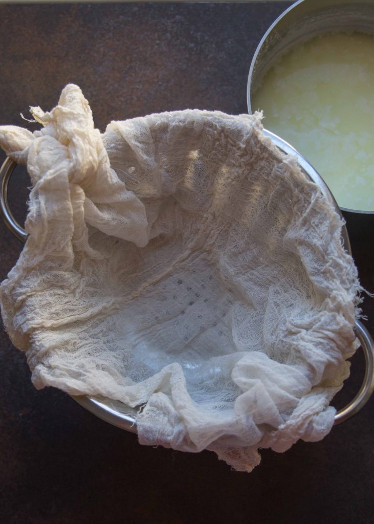 Colander lined with cheesecloth and ricotta ready to be poured in.